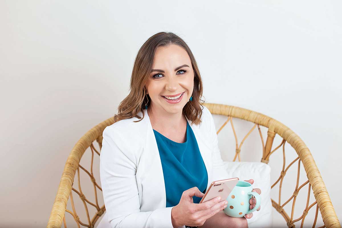 Emma Bowdler holding mug and phone