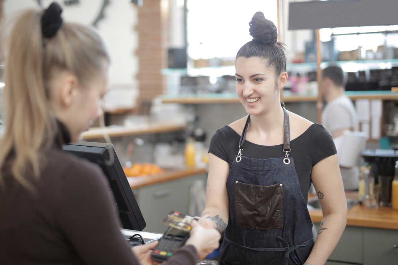 Woman Using Eftpos Machine at Checkout